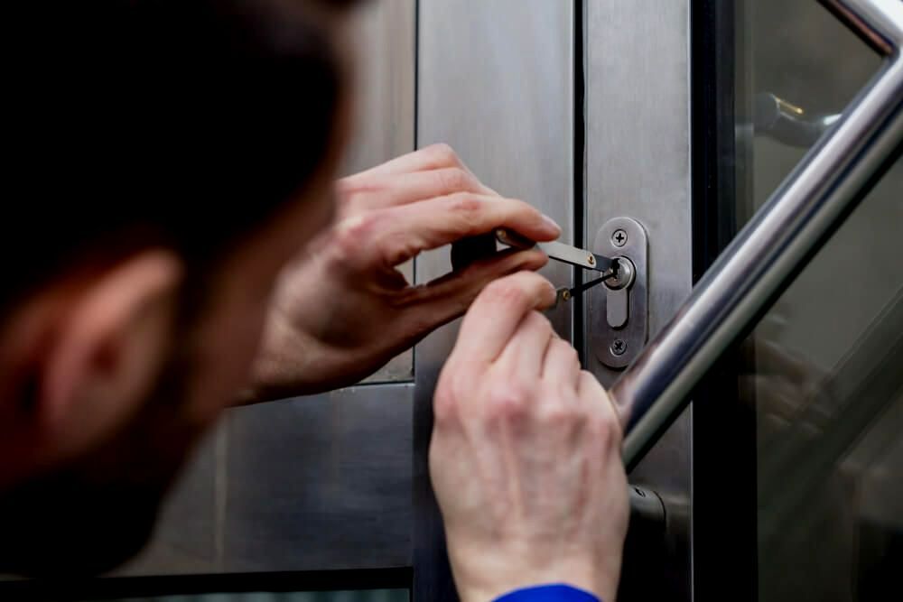 A Man Is Using A Key To Open A Door — Troy Cummings Locksmith In Cairns, QLD