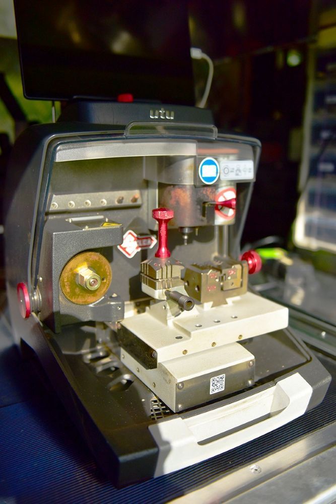A Key Cutting Machine Is Sitting On Top Of A Table — Troy Cummings Locksmith In Mornington Island, QLD