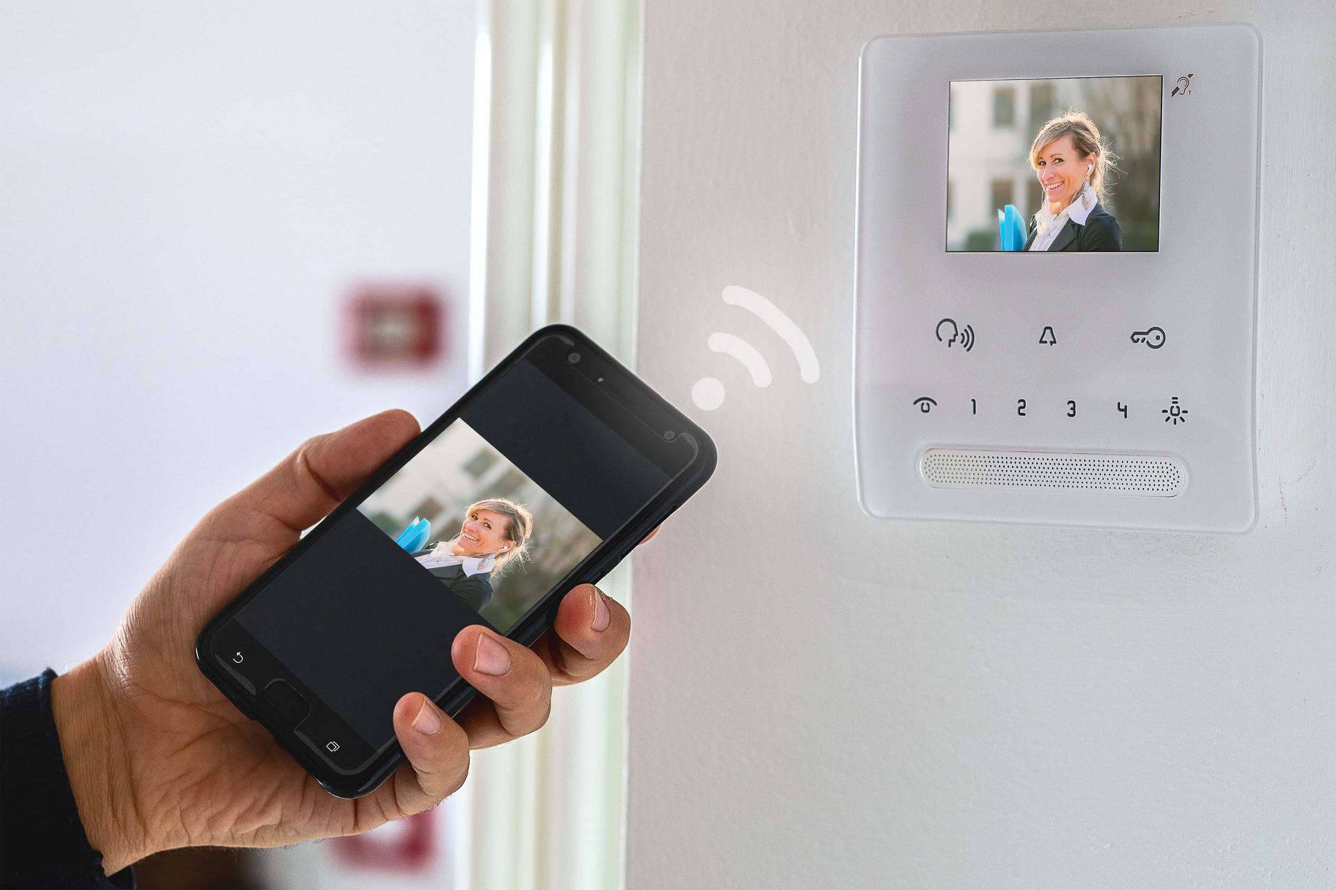 A Person Is Holding A Cell Phone In Front Of A Video Doorbell — Troy Cummings Locksmith In Cairns, QLD