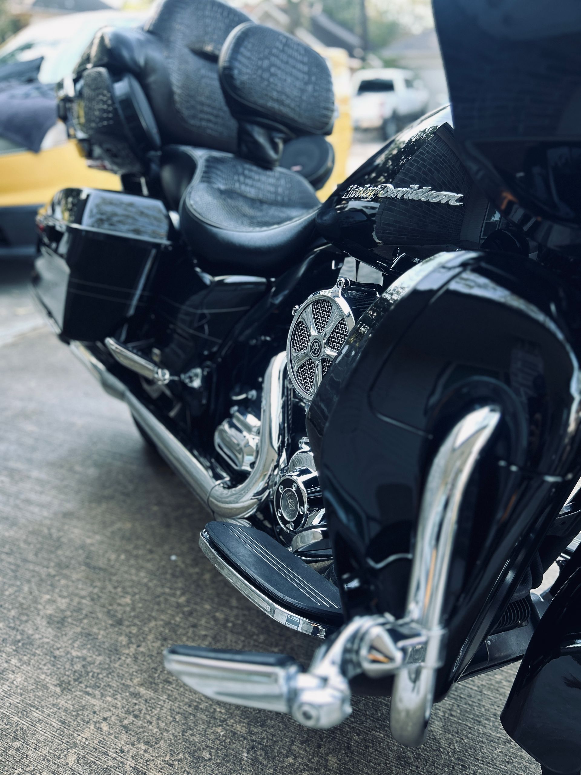Black Harley-Davidson motorcycle parked on concrete. Chrome accents, dark seat.