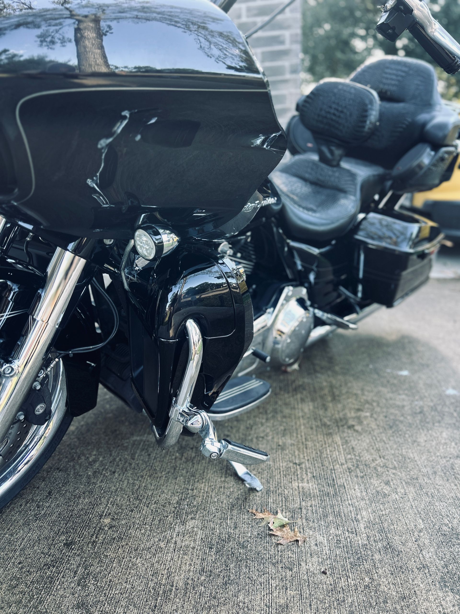 Black motorcycle parked on pavement, partially visible. Shiny chrome accents.
