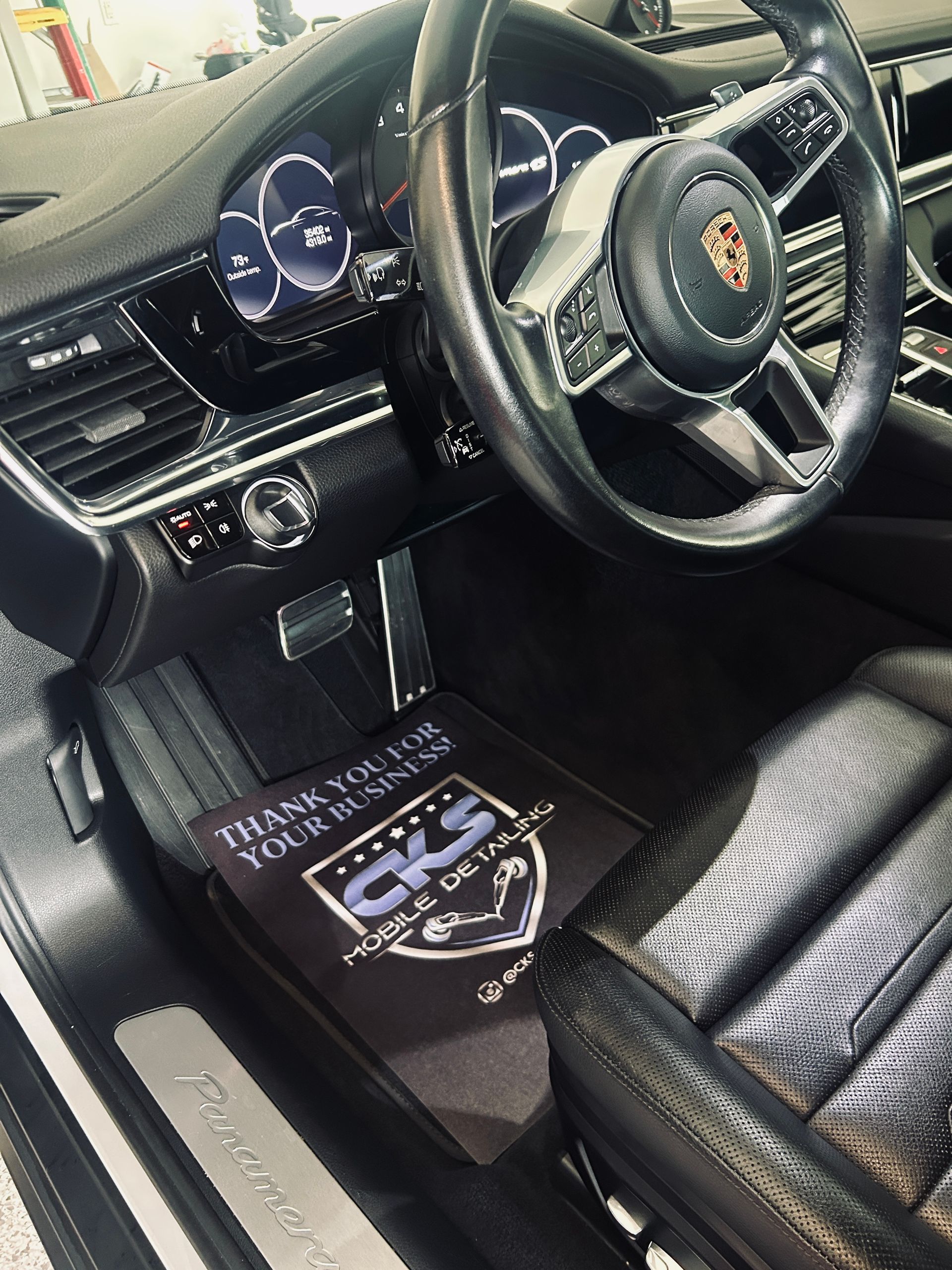 Interior of a Porsche Panamera with a floor mat that reads 