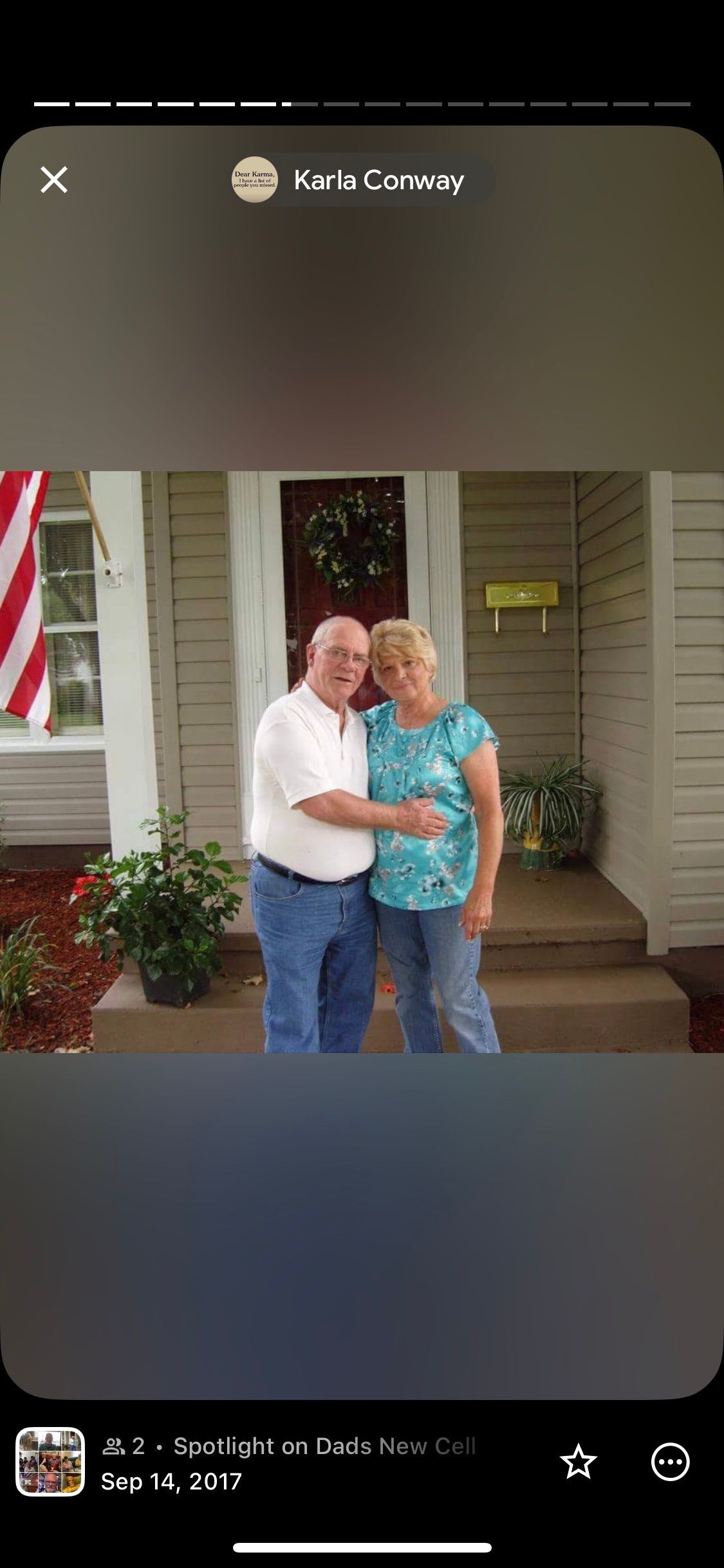 Smiling medical team in blue scrubs and white coats posing indoors, arms around each other.
