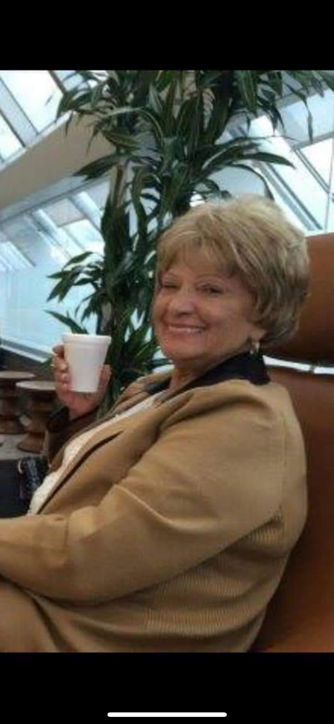 Older couple shaking hands with another person; smiling indoors.