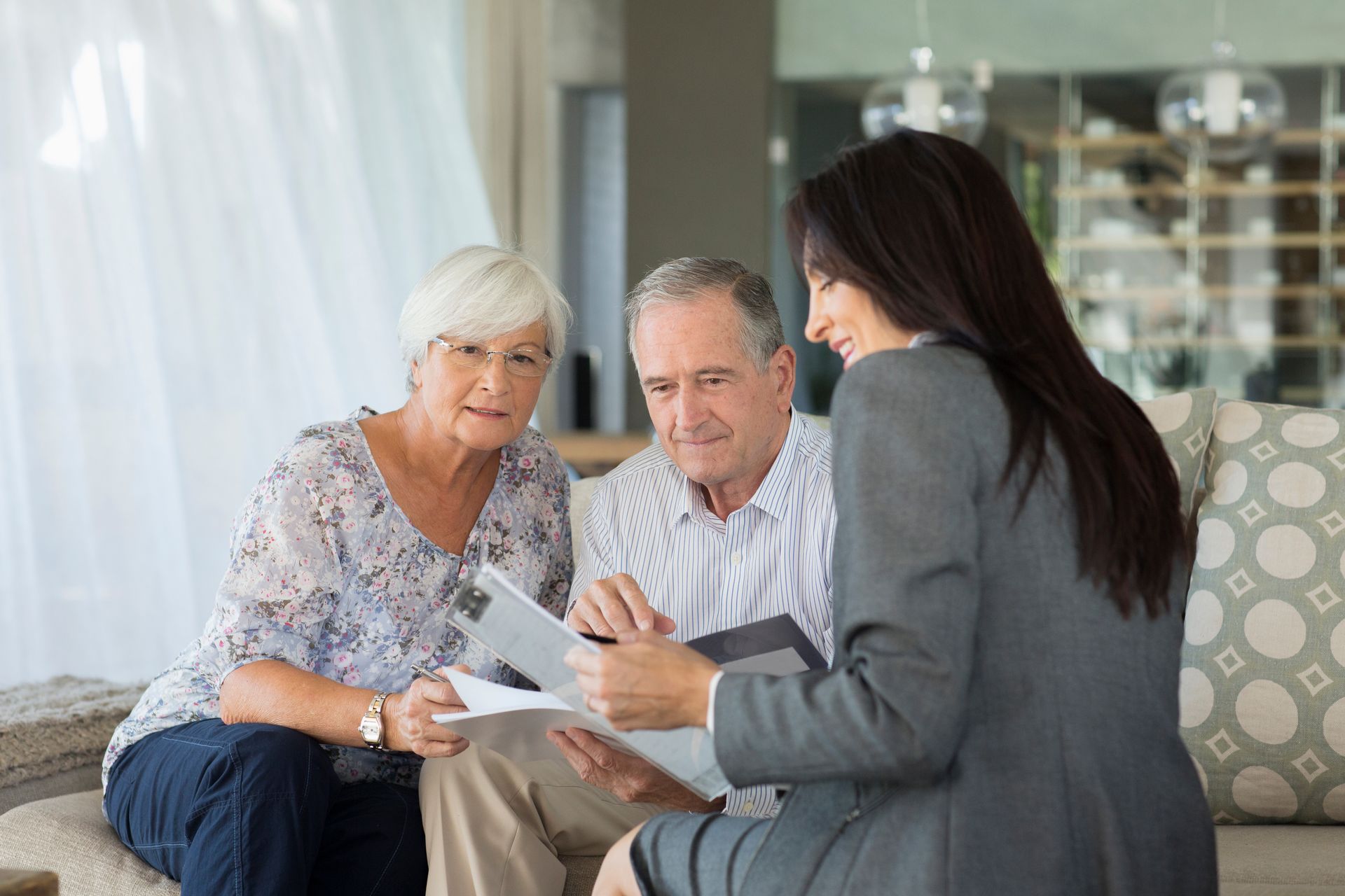 Senior couple reviewing documents with a professional, indoors.