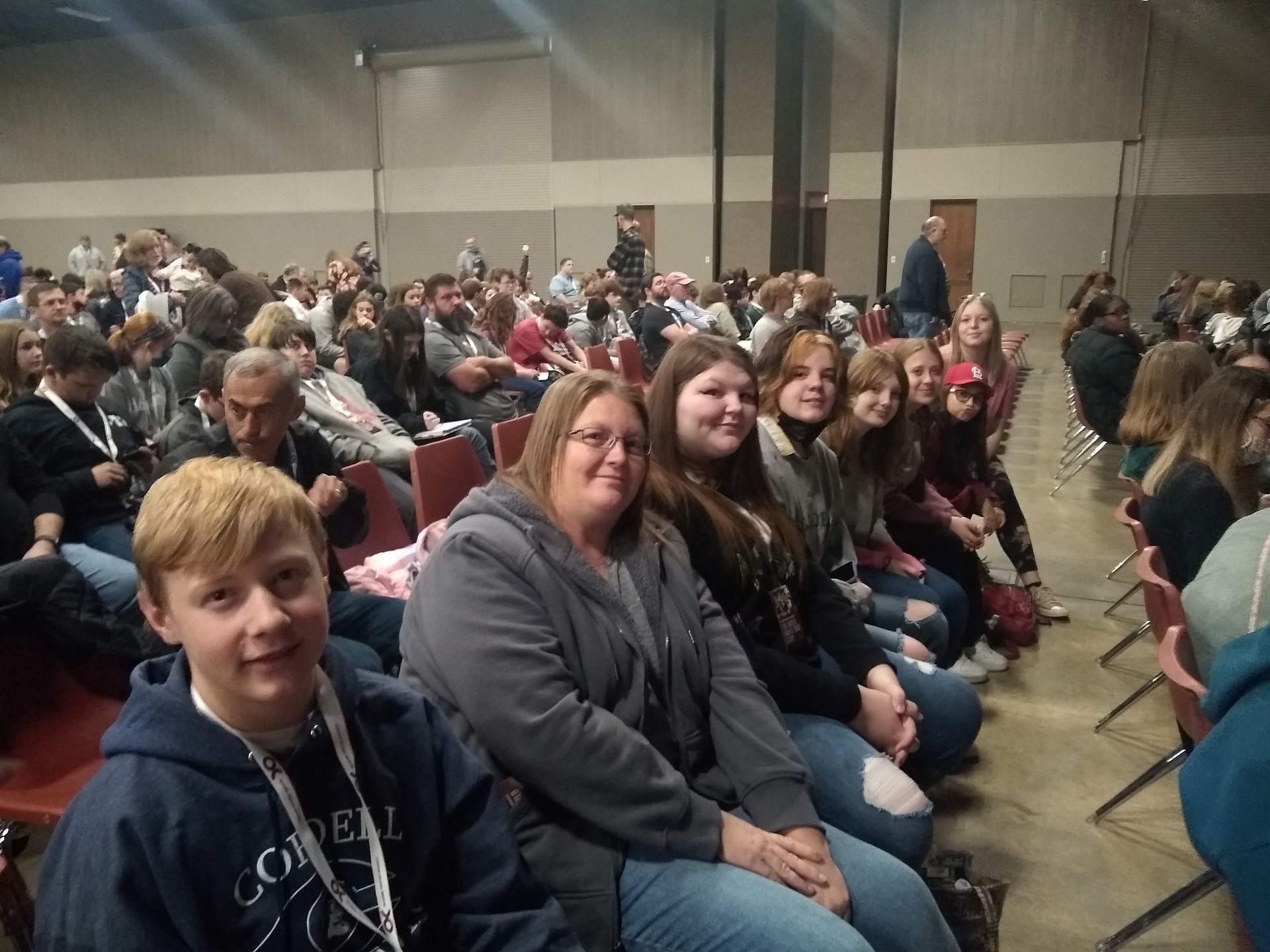 A group of people are sitting in chairs in a large room.