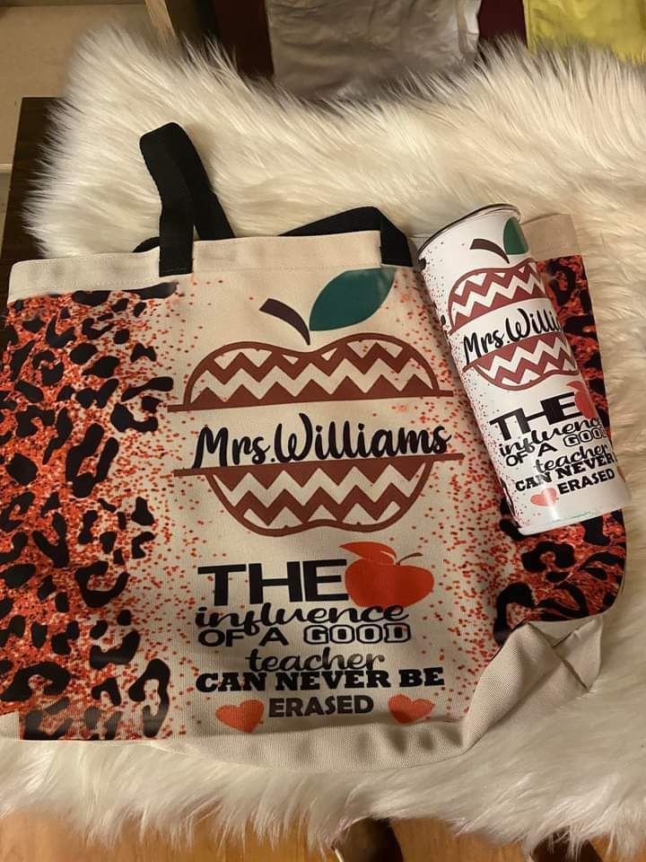 A tote bag and a tumbler are sitting on top of a furry blanket.