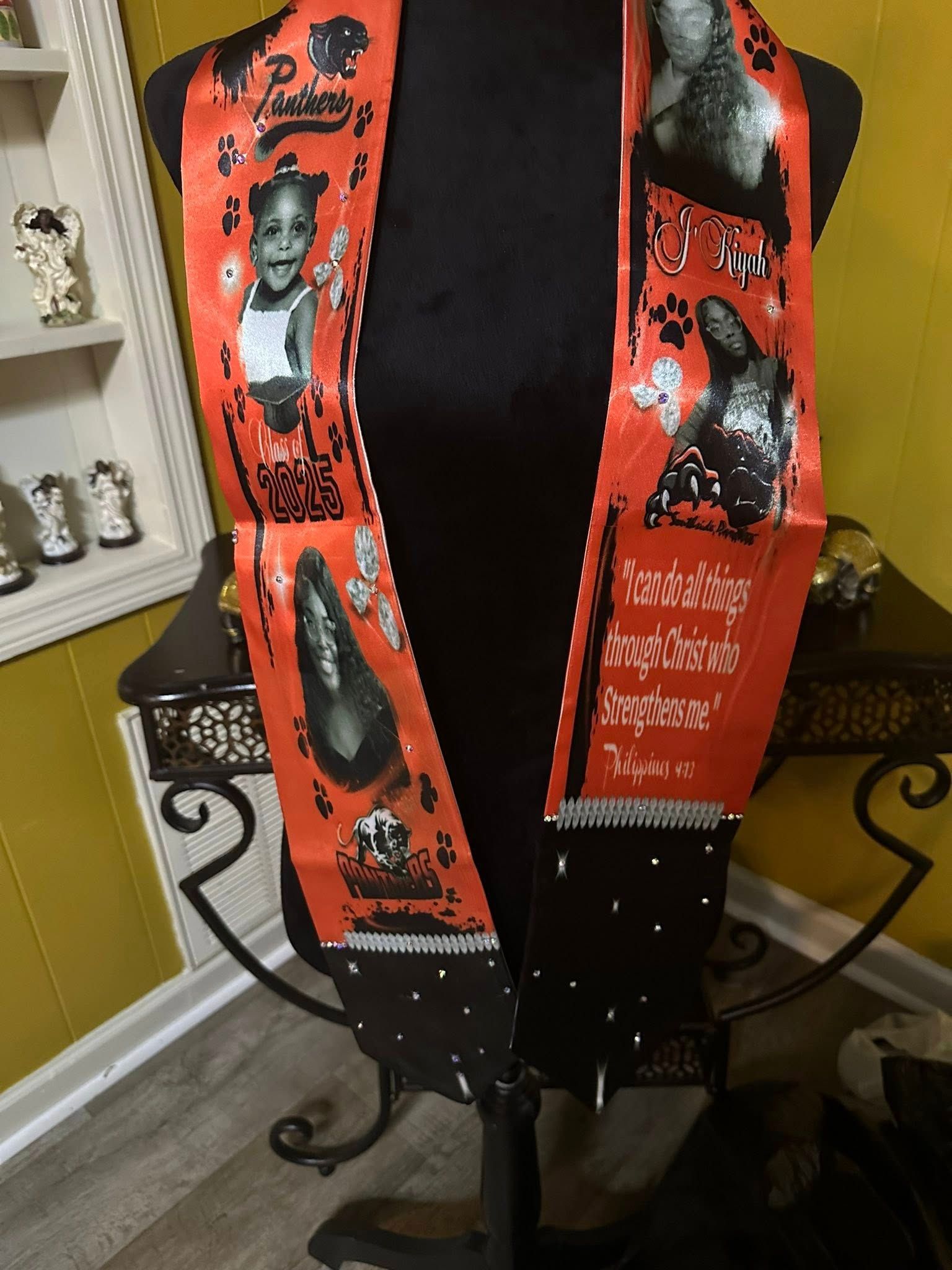 A mannequin is wearing a red scarf with pictures of people on it.