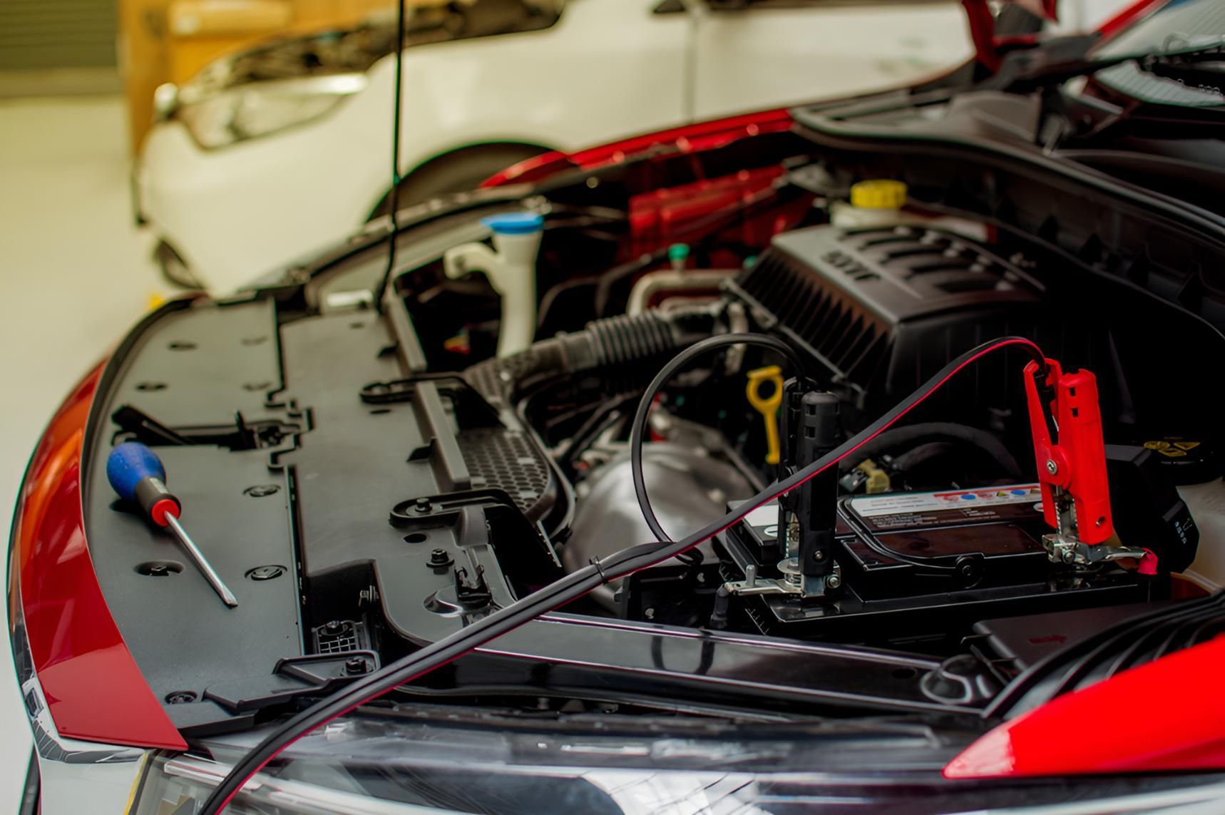 A Close Up of a Car Engine With a Jumper Cables Attached to It — Cessnock Batteries In Bellbird, NSW