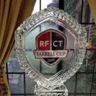 Crystal trophy with red-and-black “RFCT Farrell Cup 2017” emblem on a table near a window