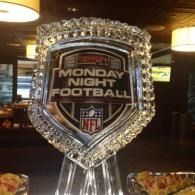 Monday Night Football NFL shield trophy on a table in a dimly lit room.