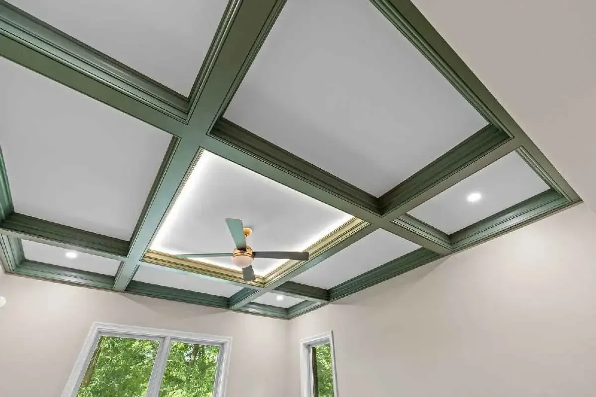 Coffered ceiling painted in sage green with white recessed panels, a central ceiling fan, and integrated lighting.