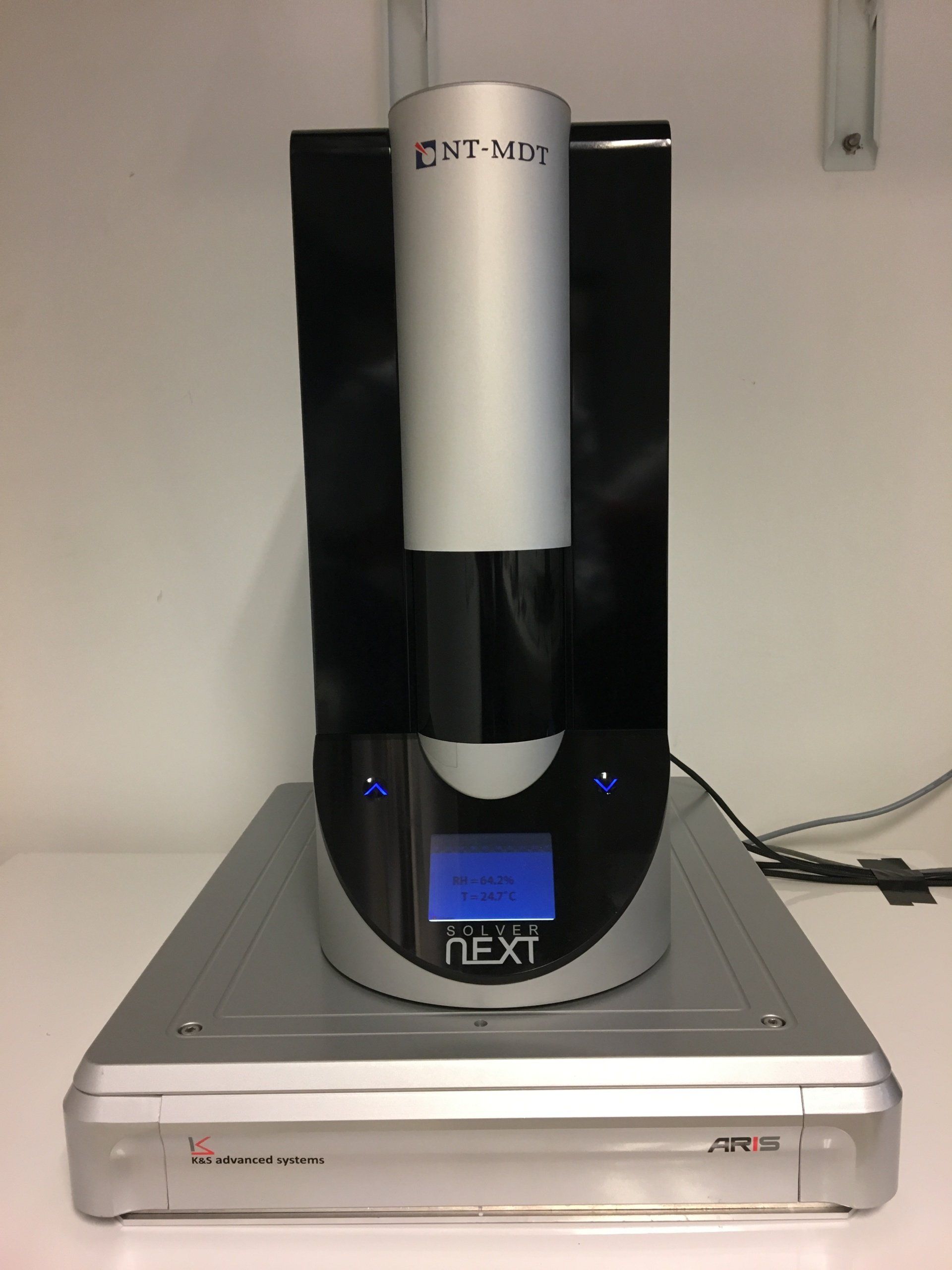 Close-up of a laboratory device with a sleek black and silver design, featuring illuminated control buttons