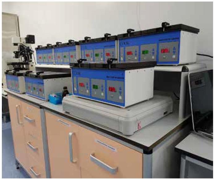 Multiple laboratory control units on an ARIS vibration isolation platform, organized on a bench in a research lab environment