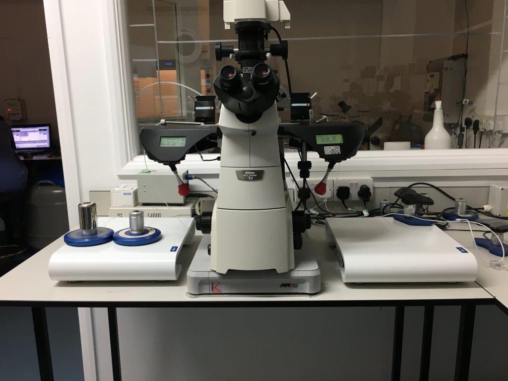 Advanced laboratory microscope mounted on an ARIS vibration isolation platform, with calibration weights and control units 