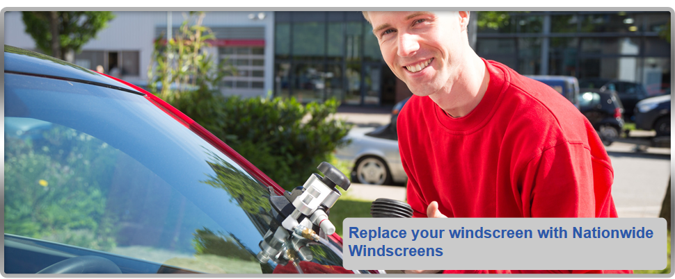 man holding windscreen repair tools over a car windscreen