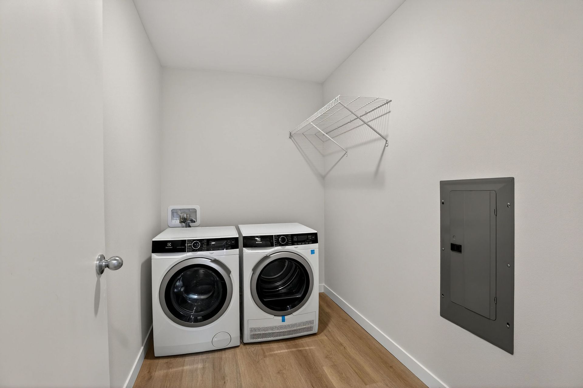 Laundry room with a washer and dryer, drying rack, and electrical panel.