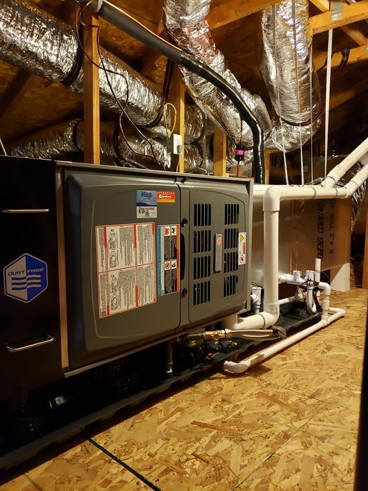 An air conditioner is sitting in the attic of a house.