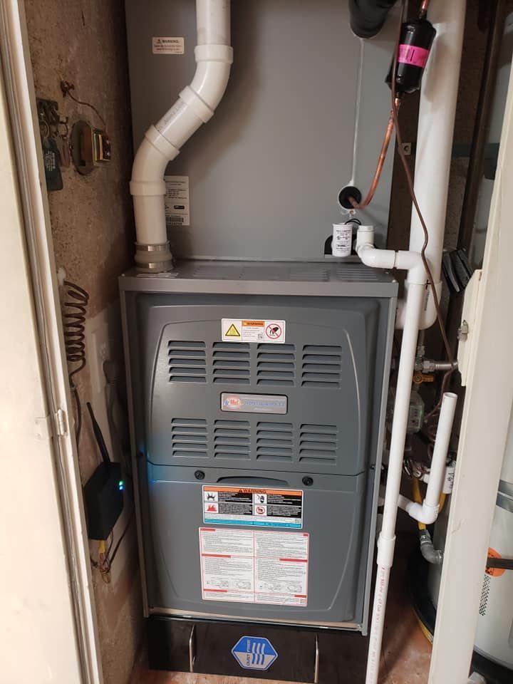 A gas furnace is sitting in a corner of a room.