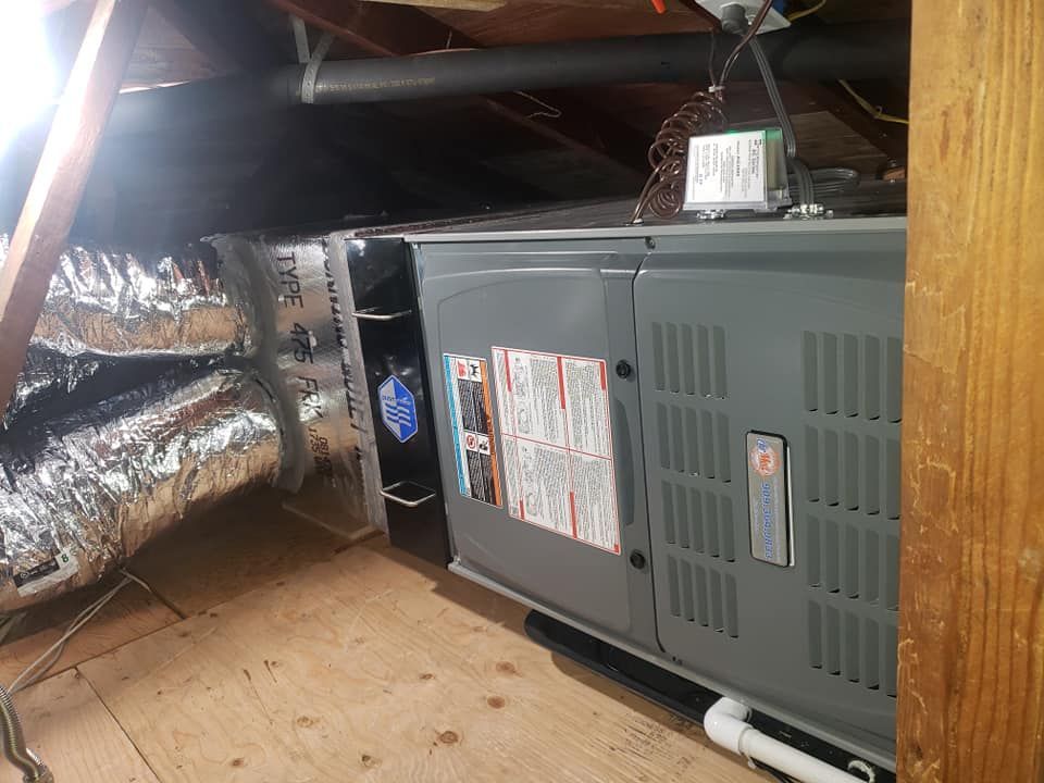 An air conditioner is sitting in the attic of a house.