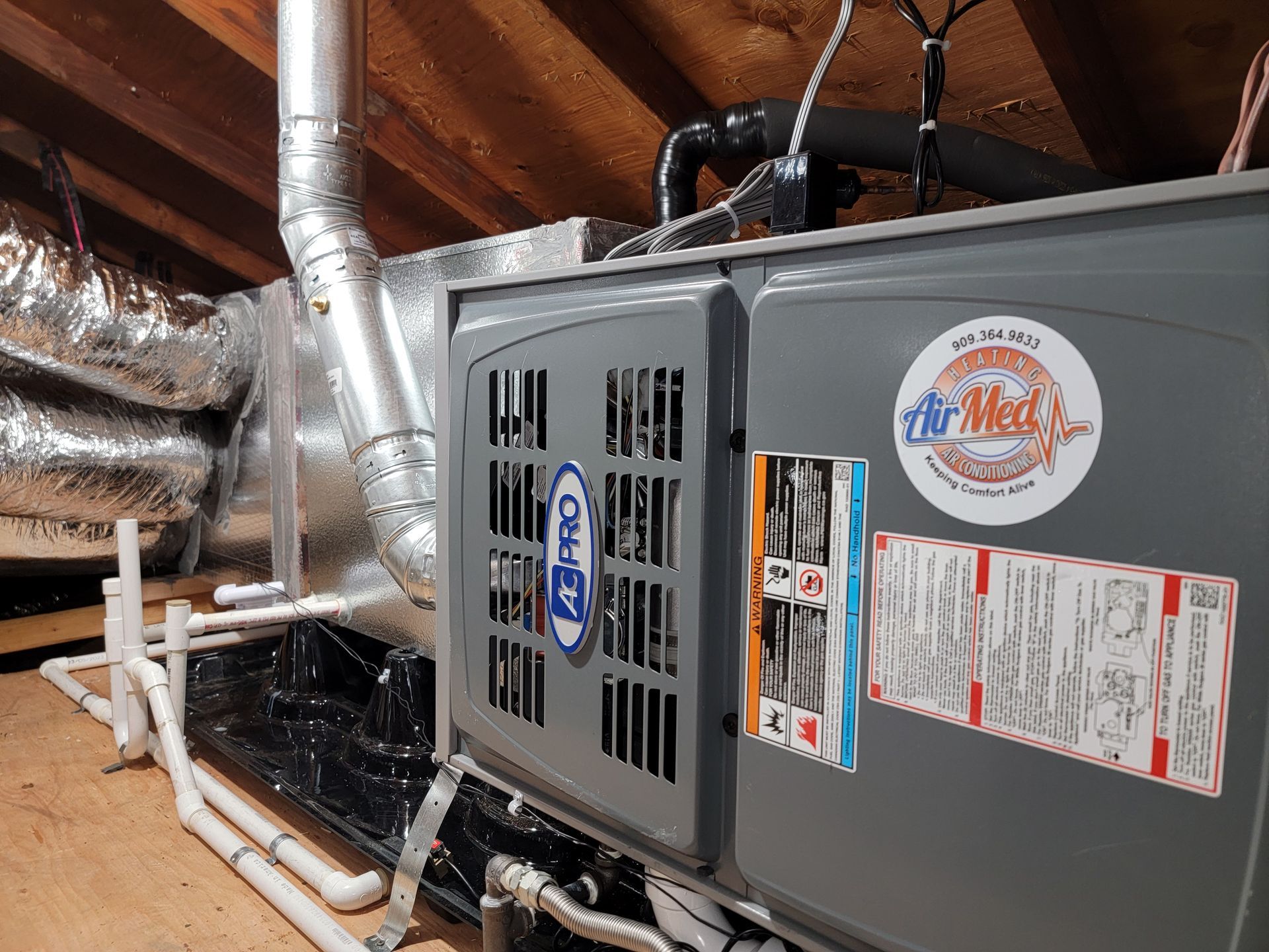 An air conditioner is sitting in the attic of a house.