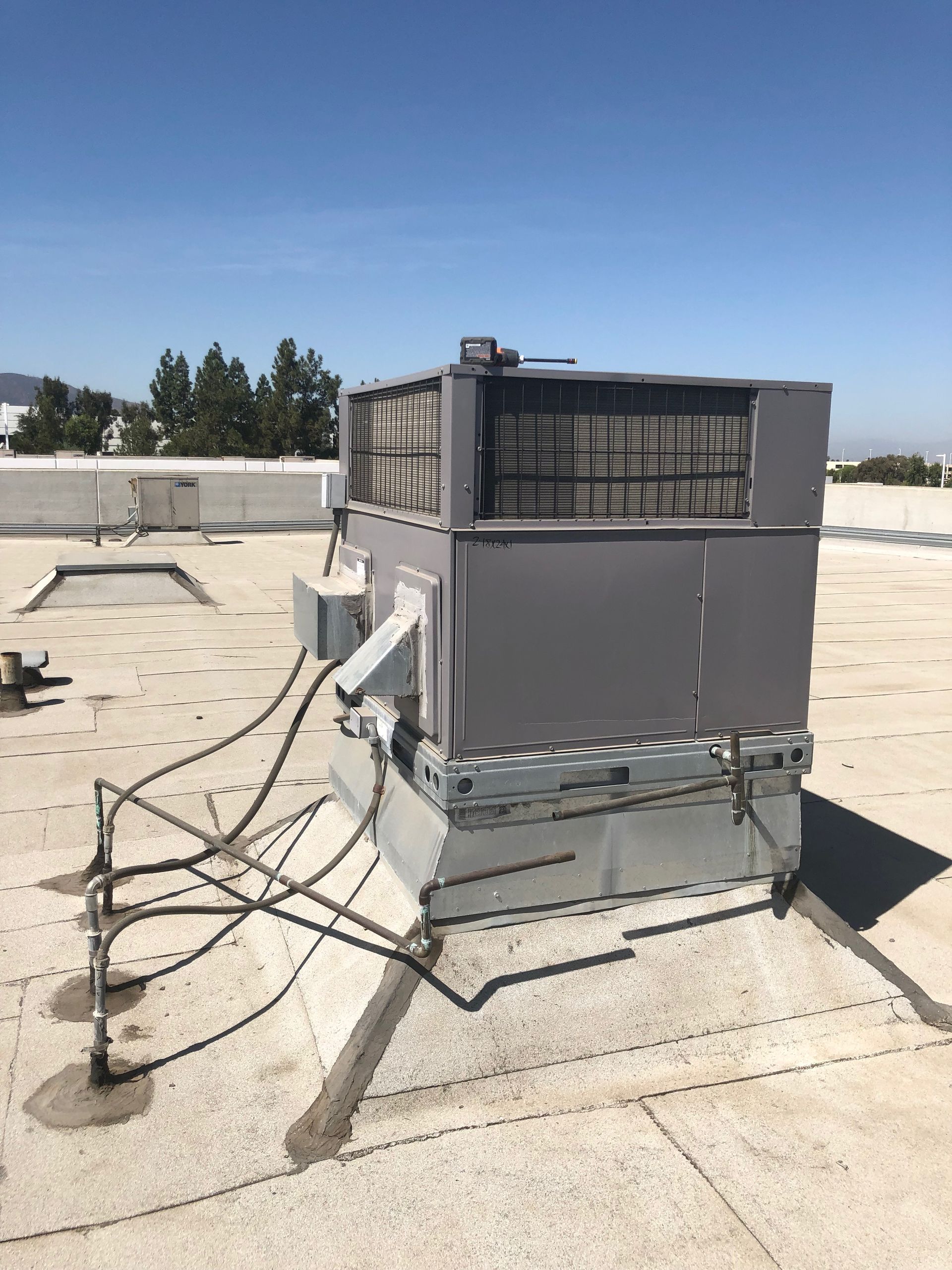 A large air conditioner is sitting on top of a roof.