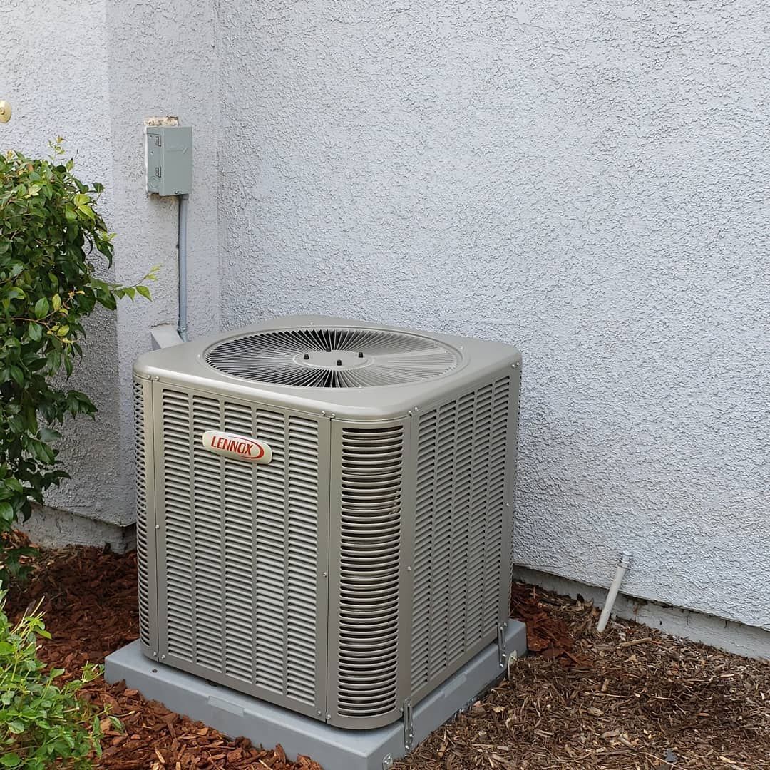 An air conditioner is sitting on the side of a building.