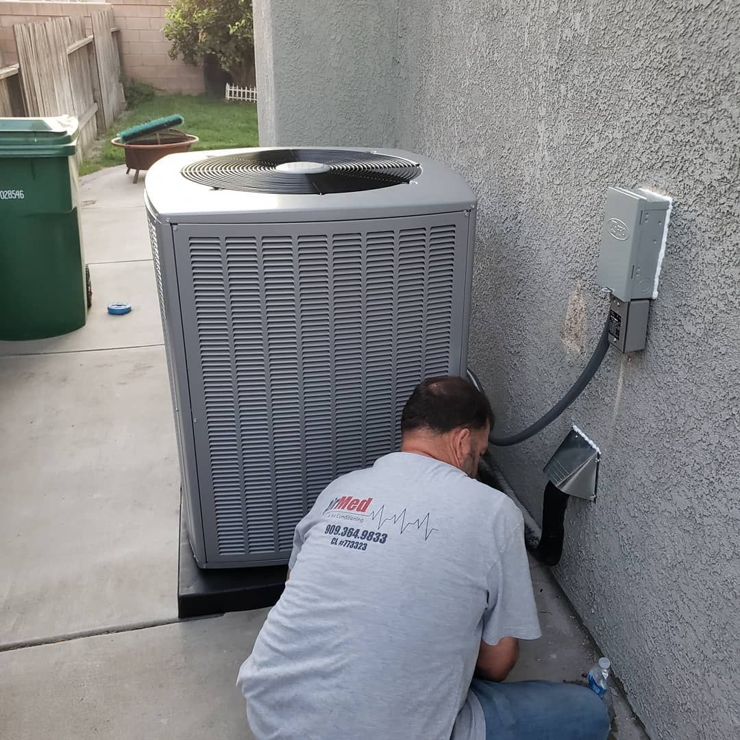 A man is working on an air conditioner outside