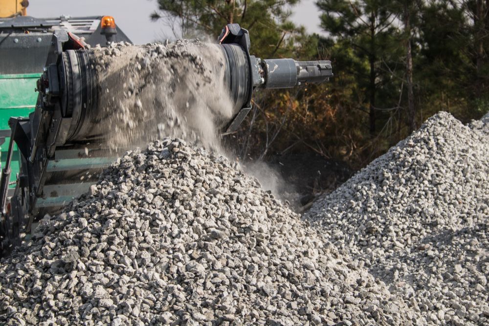 Rock Crusher Machine Spews Gravel Into a Pile, Creating Dust — Boland Contracting In Orange, NSW