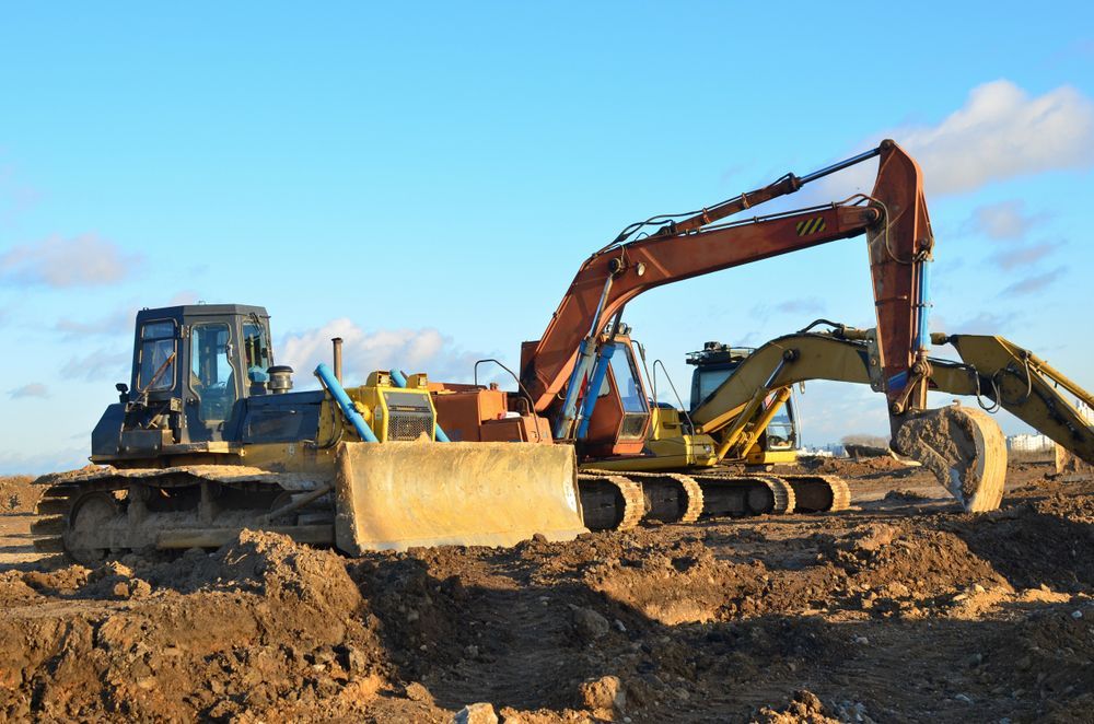Bulldozer and Excavator on a Dirt Construction Site Under a Clear Blue Sky — Boland Contracting In Wellington, NSW