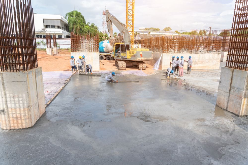 Construction Workers Pouring Wet Concrete at a Construction Site — Boland Contracting In Wellington, NSW