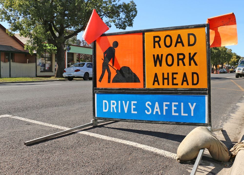 Road Work Sign on a Street Orange and Blue Colours With a Worker — Boland Contracting In Wellington, NSW