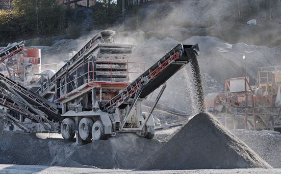 Yellow Excavator Demolishing a Building Creating Dust in a Sunny Outdoor Setting — Boland Contracting In Wellington, NSW