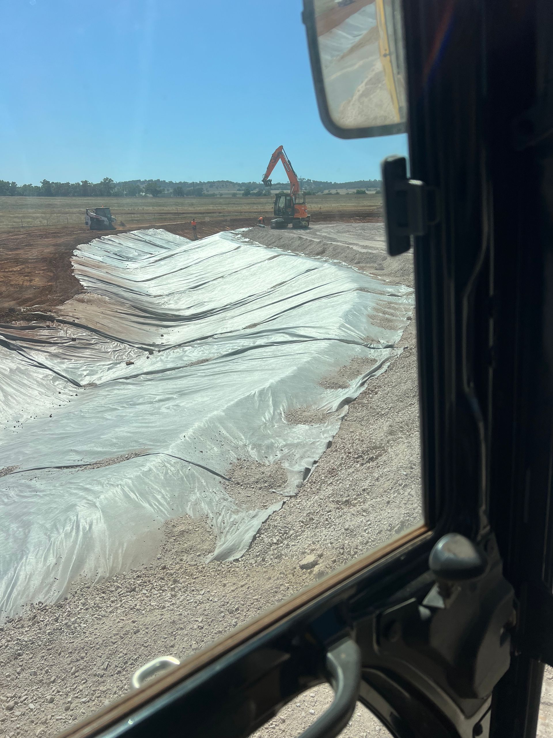 View From Vehicle of Construction Site Covered Area With Machinery and Excavator — Boland Contracting In Wellington, NSW
