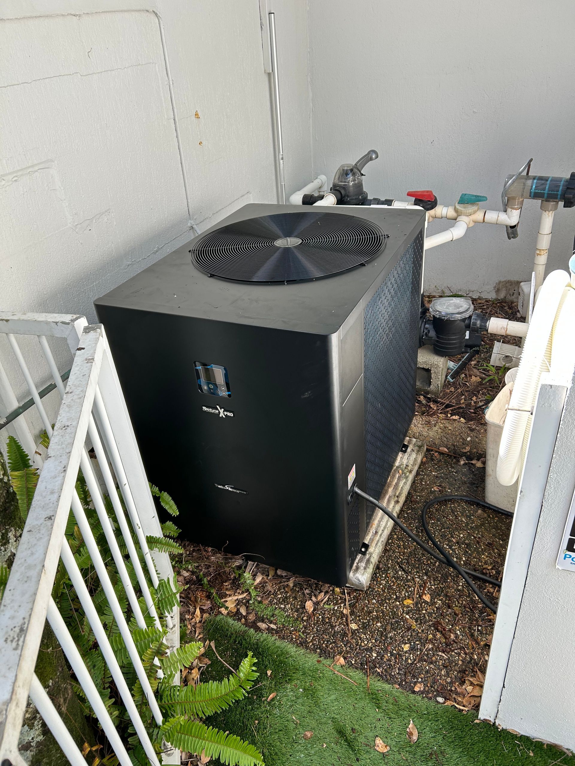 Outdoor Hvac Unit Beside a House, With a Black Top Fan and White Side Panels in a Narrow Side Yard — Bromage Pool Heating in Maroochydore, QLD