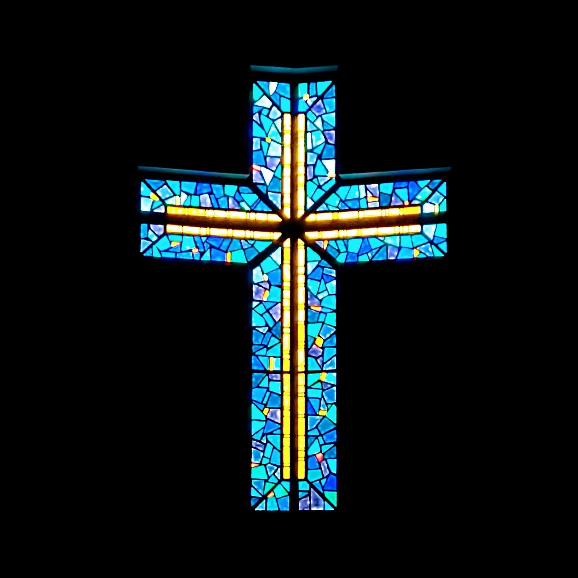 a stained glass cross on a black background