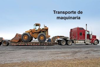 Un camión rojo lleva una topadora en un remolque.