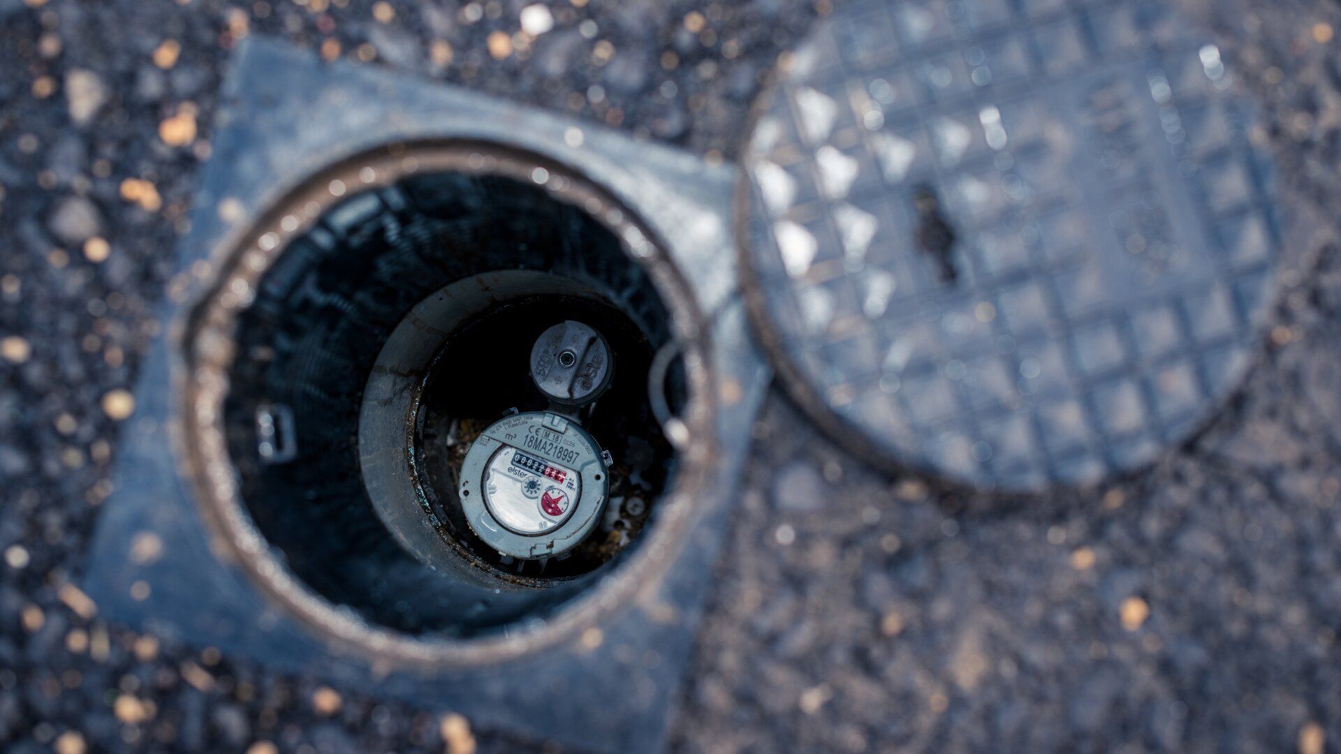 A manhole cover with a water meter inside of it.