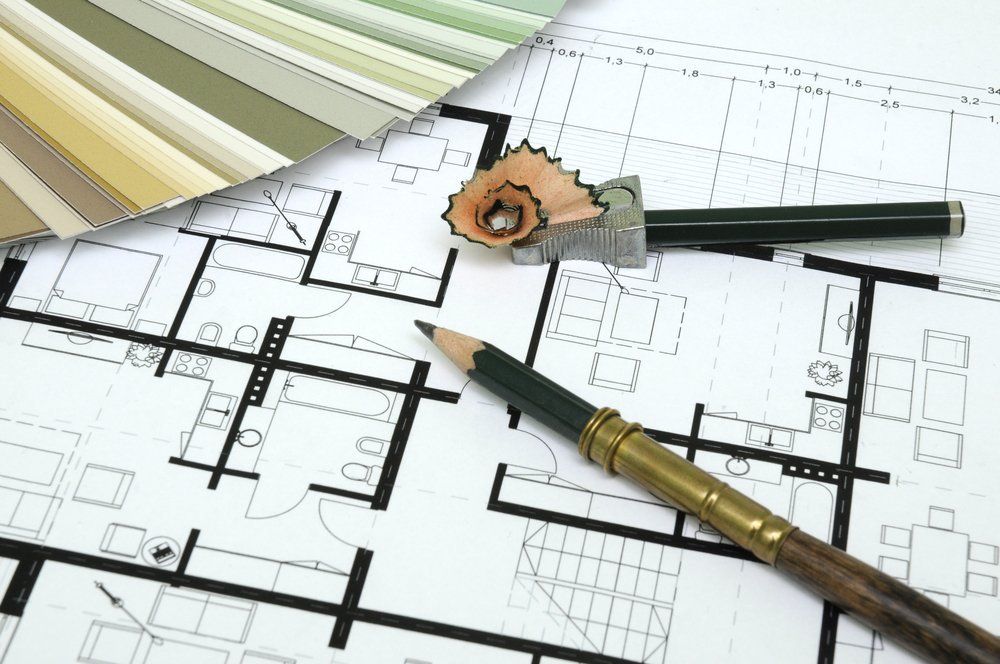 Auf der Zeichnung eines Hauses liegt ein Bleistift.