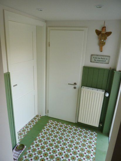 Ein Flur mit einer grünen Wand und einer weißen Tür