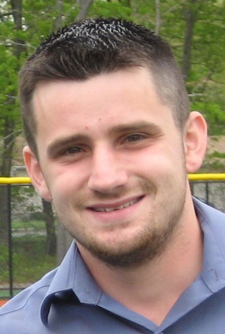 A man with a beard and a blue shirt is smiling for the camera.