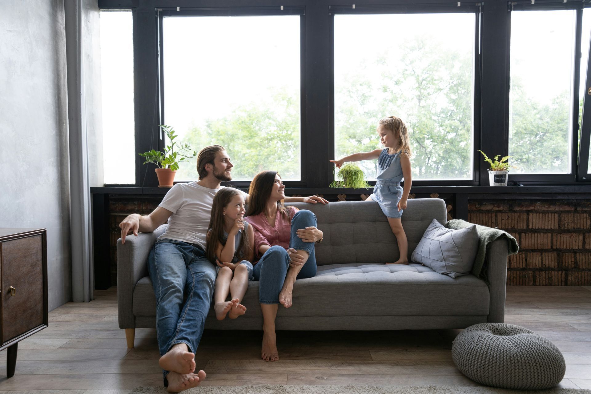 A family is sitting on a couch in a living room.