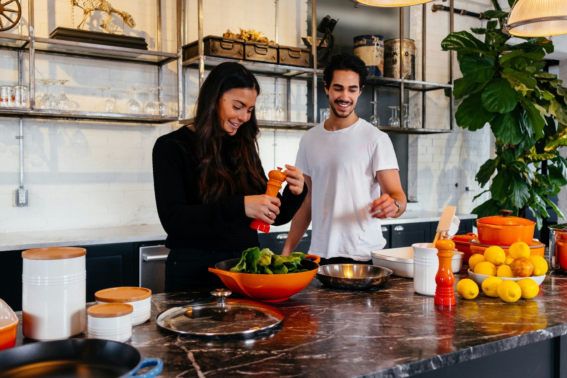 A man and a woman are preparing food in a kitchen.