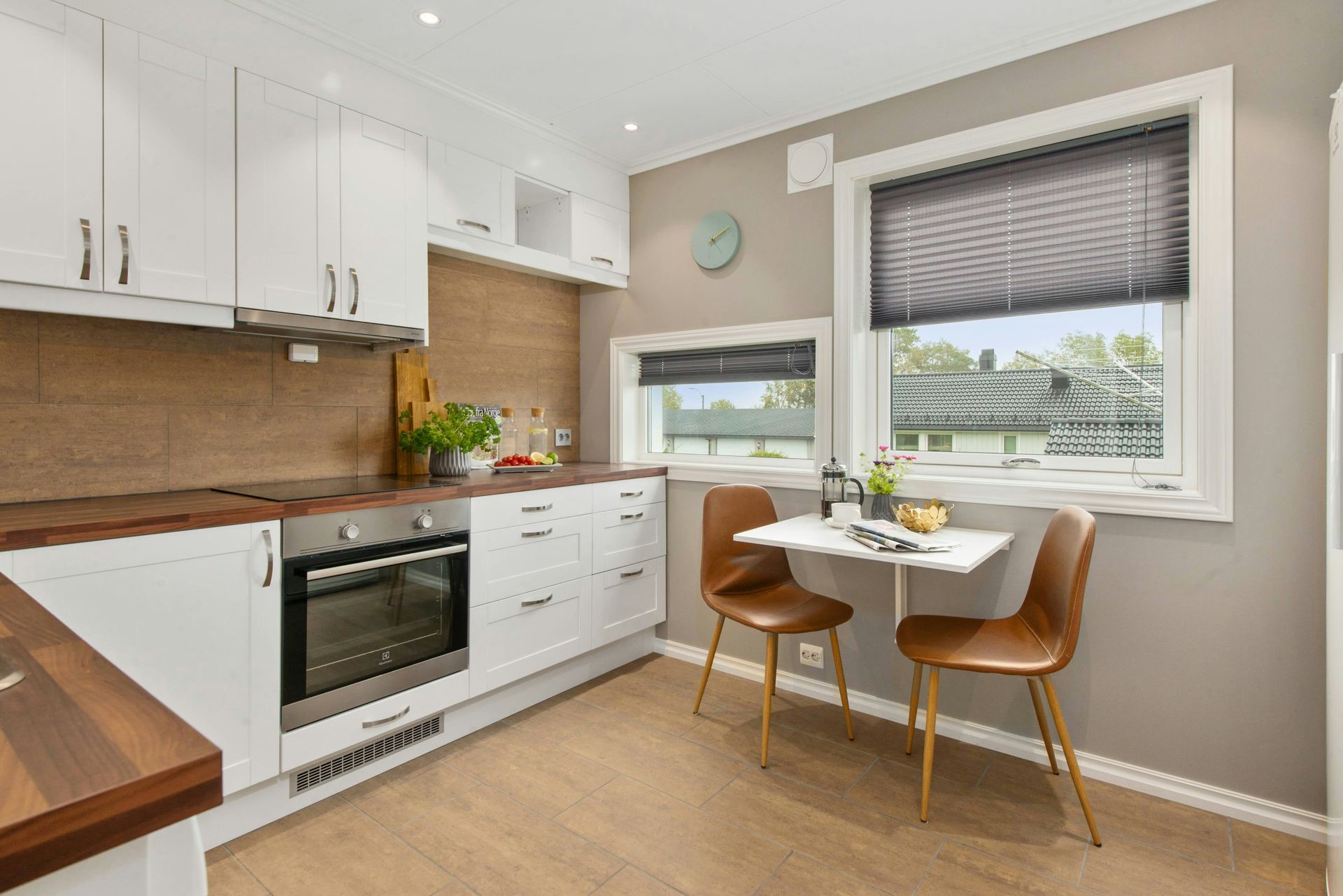 a kitchen with a table and chairs in front of a window .