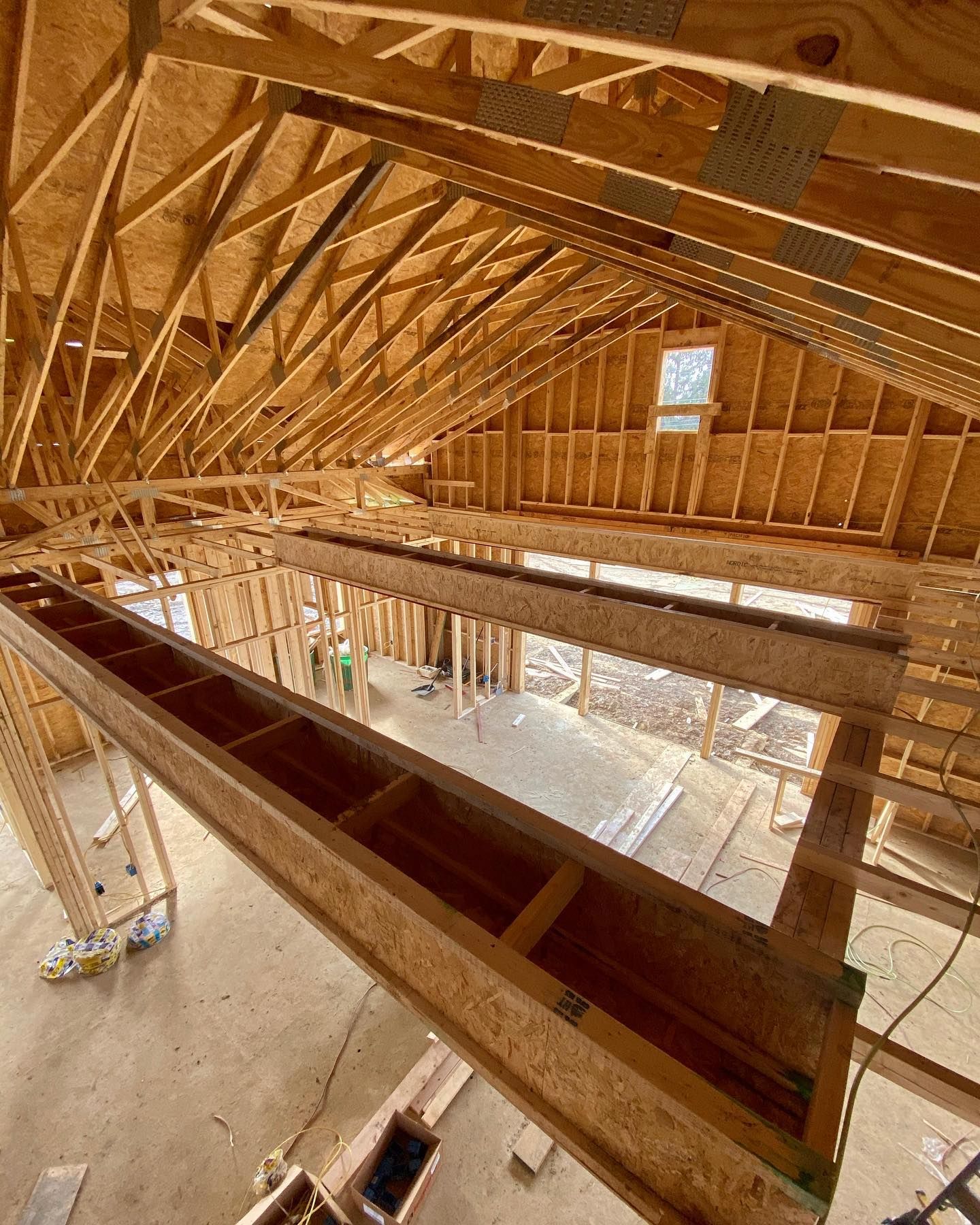 A white truck is towing a dump truck in a rocky area.