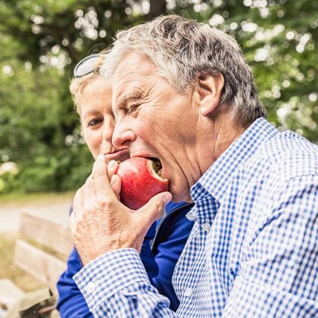 old man biting an apple