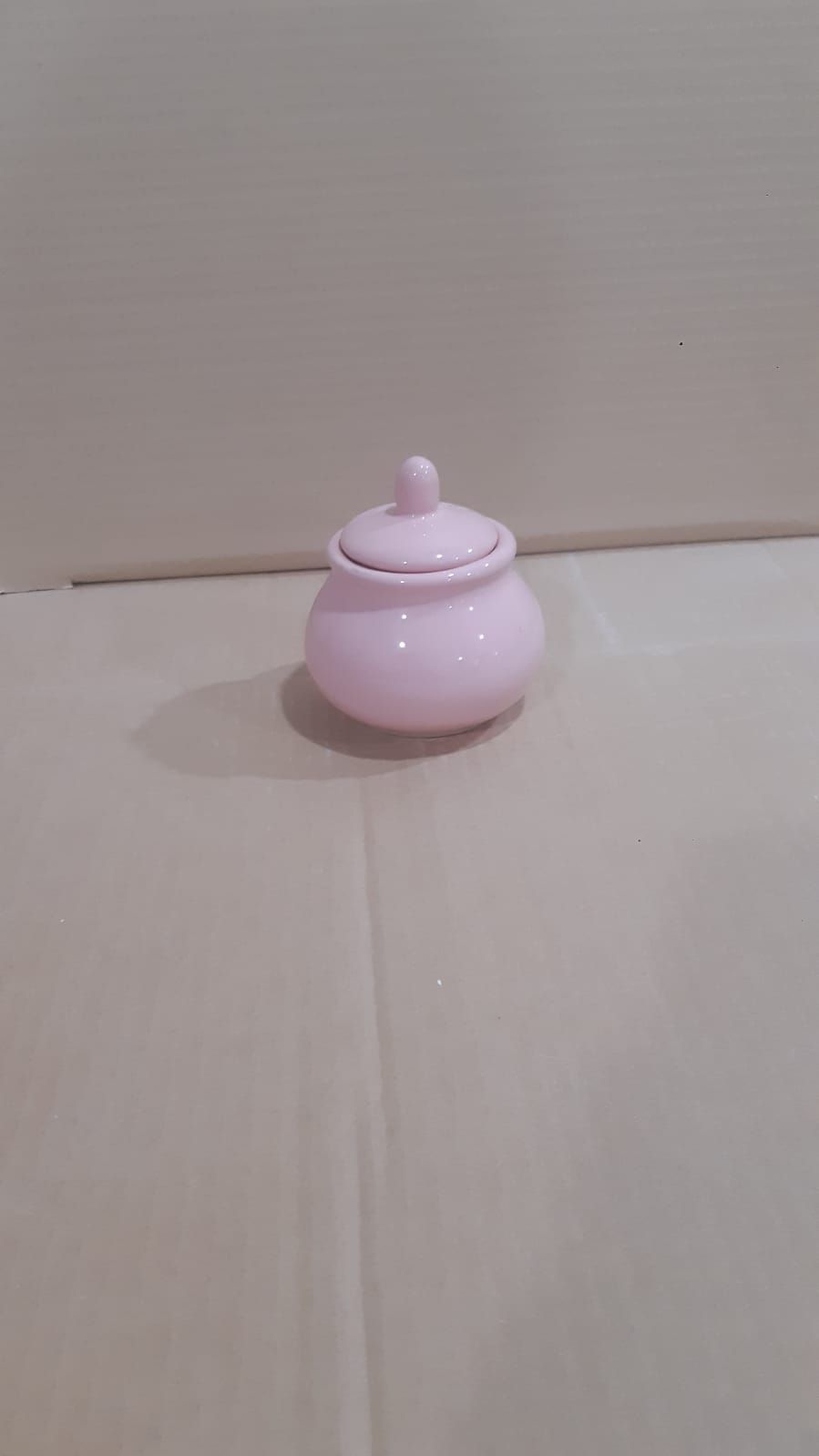 Azucarero de cerámica rosa con tapa.