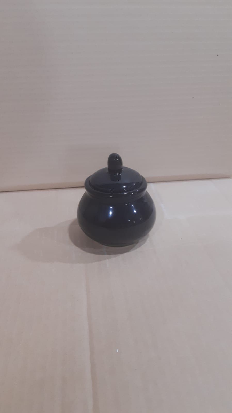 Azucarero de cerámica rosa con tapa.