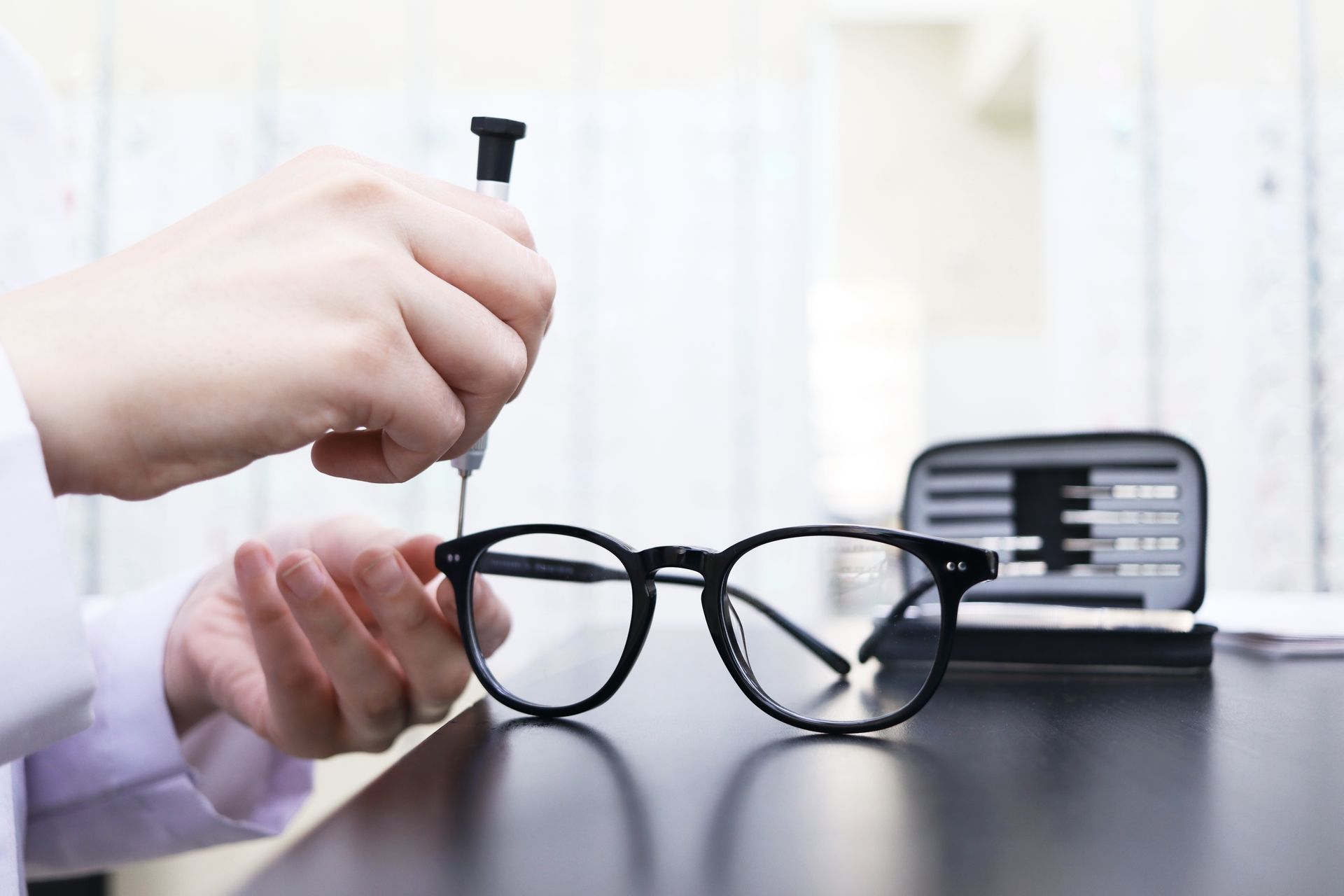 A person is fixing a pair of glasses