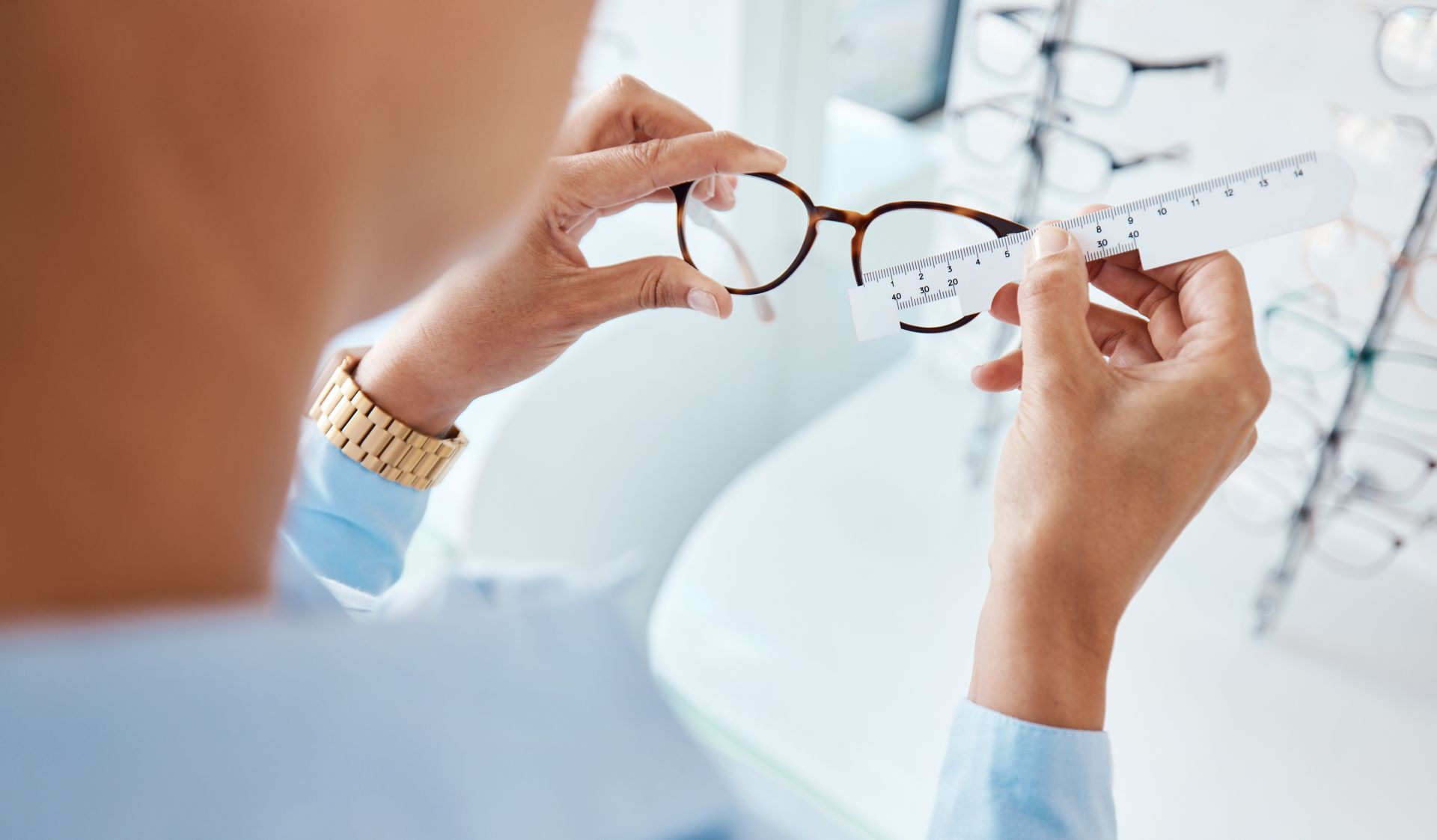 A woman is holding a pair of glasses in her hands